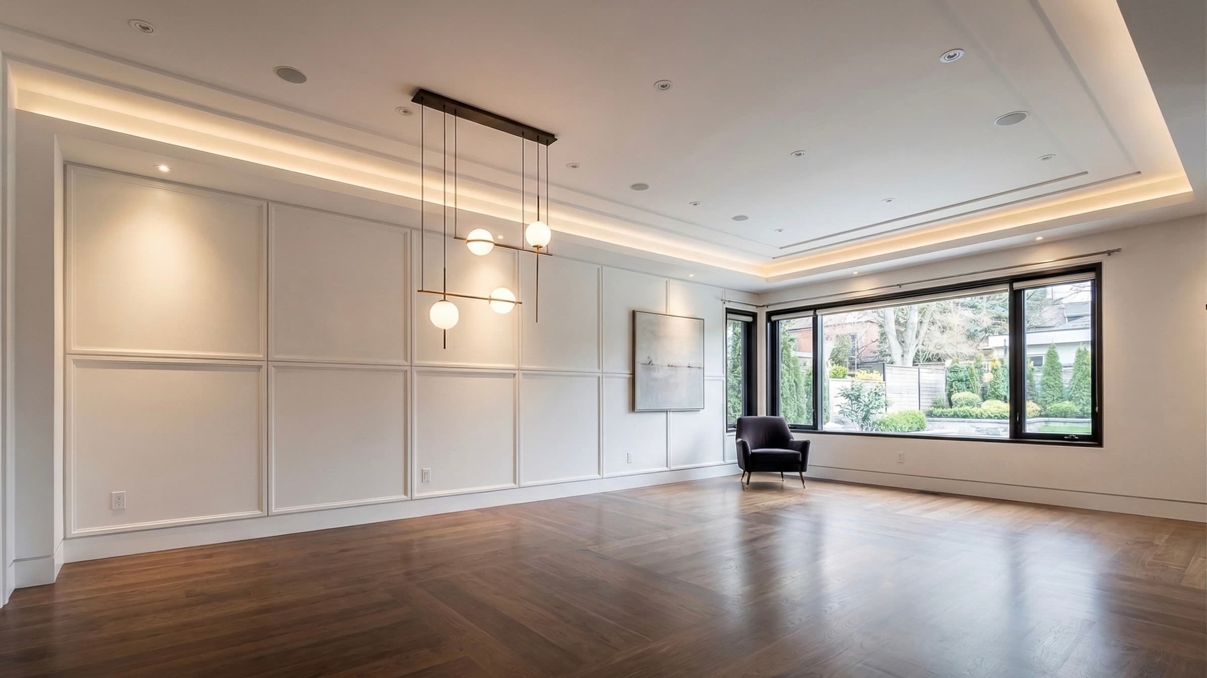 Living room with full-wall panel moulding, cove lighting and hardwood floors